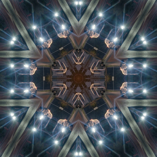 A symmetrical kaleidoscopic artwork showing a futuristic architectural ceiling with metallic beams, glowing blue and white lights, and a dark central hub.